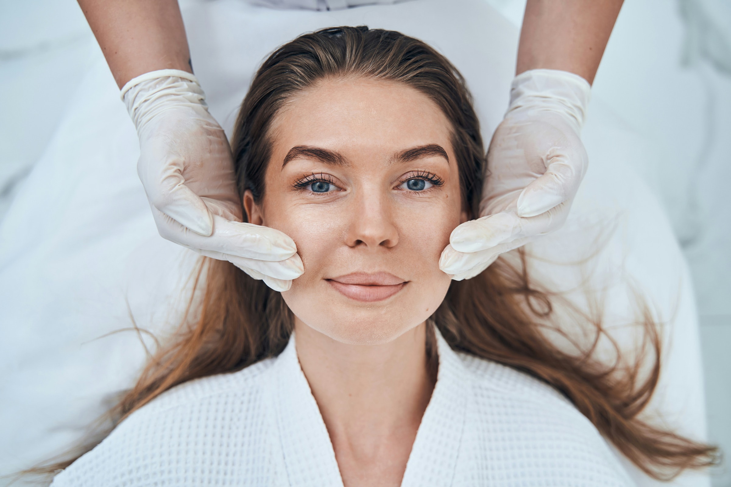A close-up of a practitioner administering a facial treatment